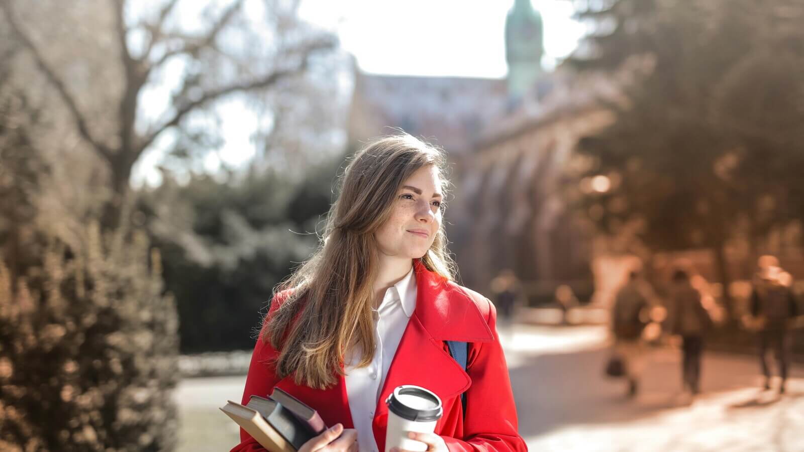 College Student on campus with books and a coffee