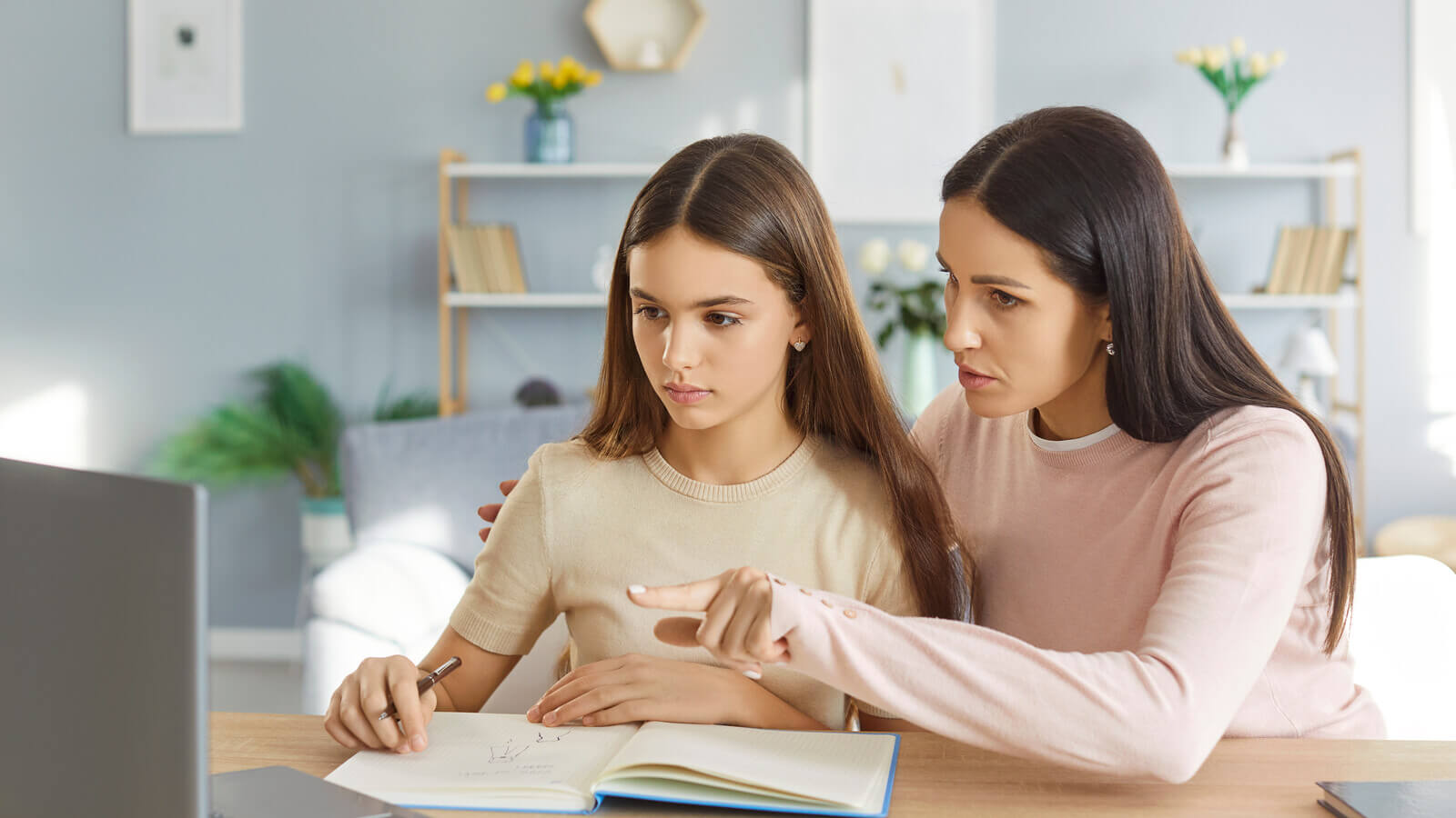 Parent sits with teen at a computer screen