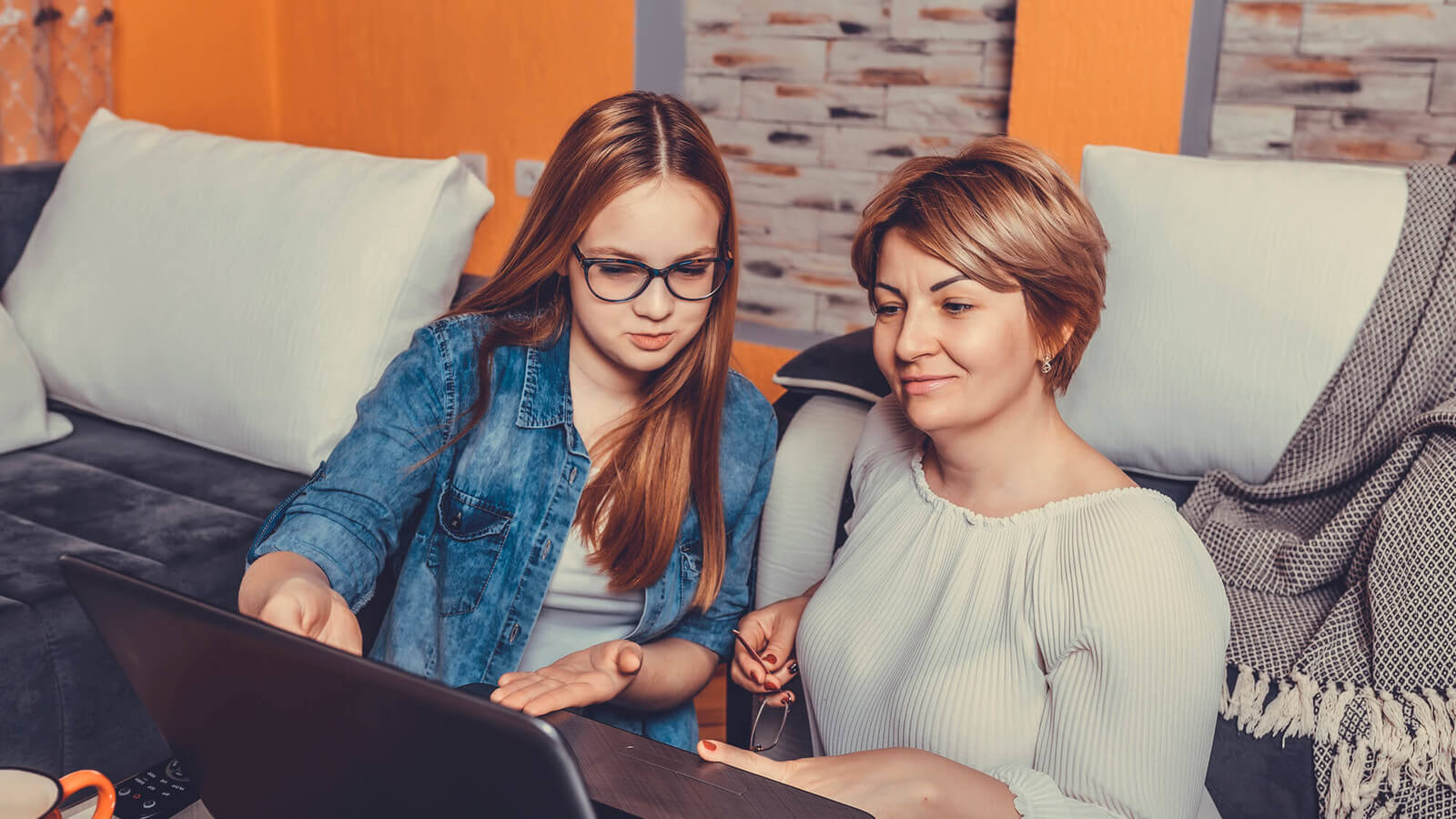 a mother and daughter discuss the 2023 FAFSA while looking at a laptop computer