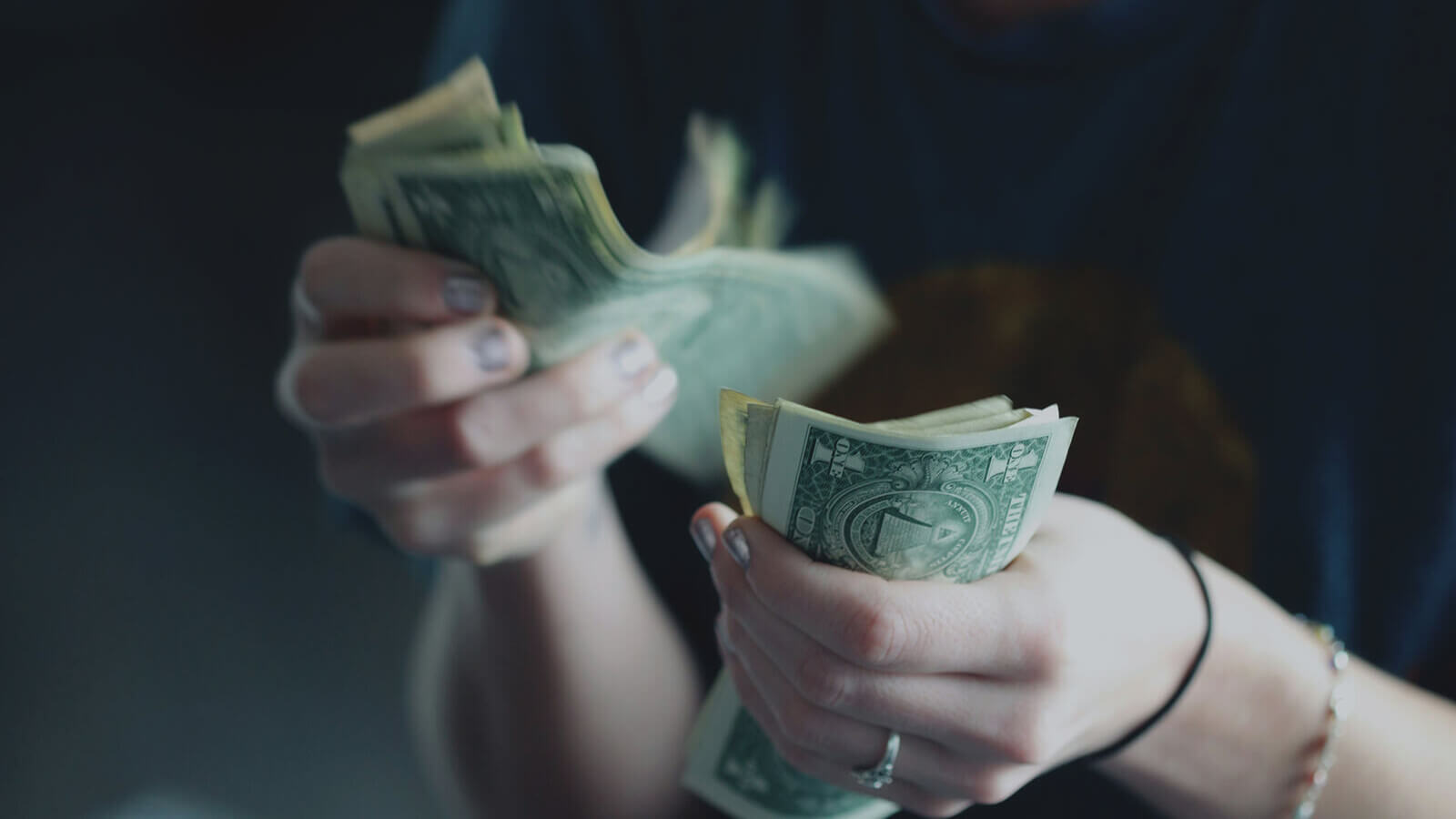 A person counting printed money in their hands.