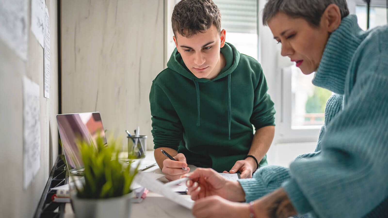 A male student getting information from a female guardian.