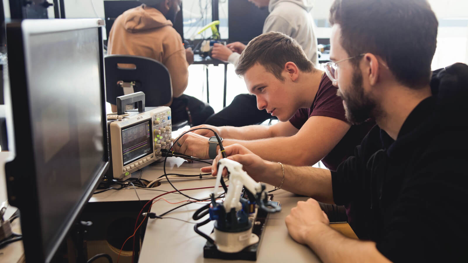 two male students working in a lab on a project