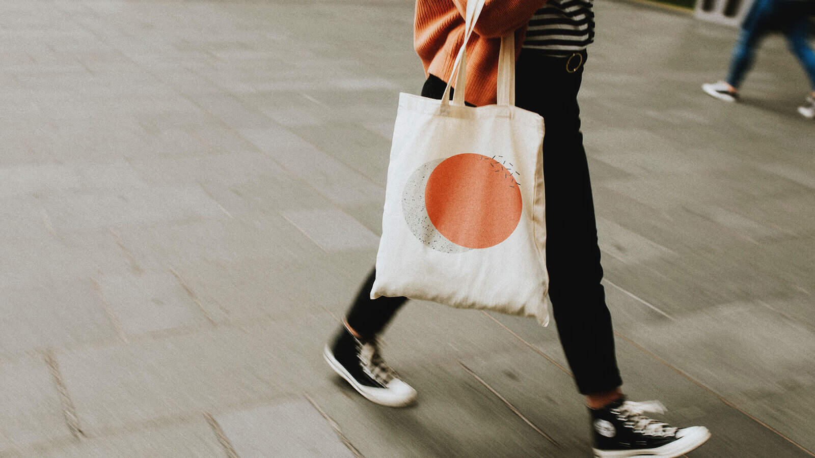 a student walks through a college fair carrying a tote bag