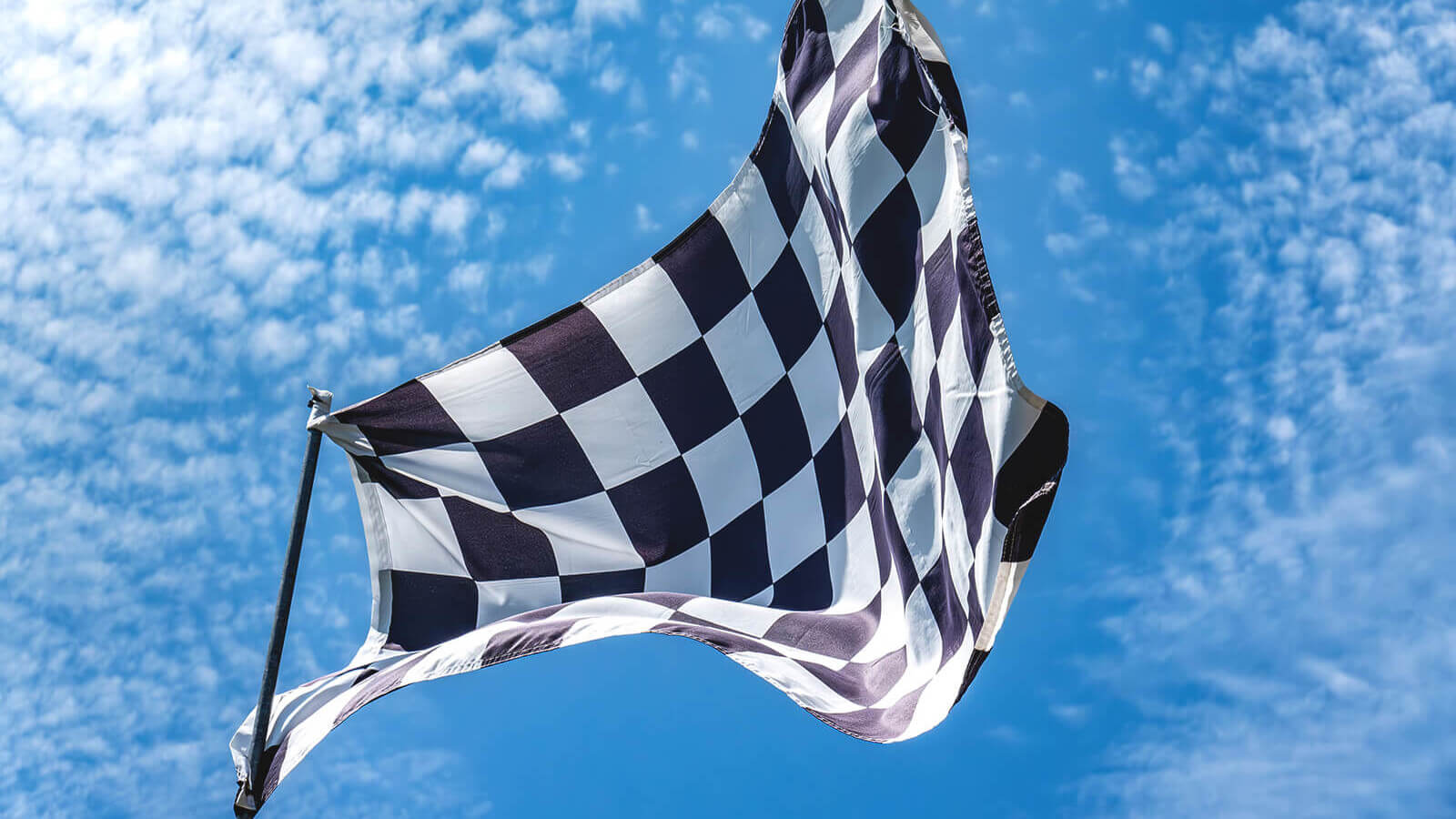 a finish line checkered flag blowing in the air