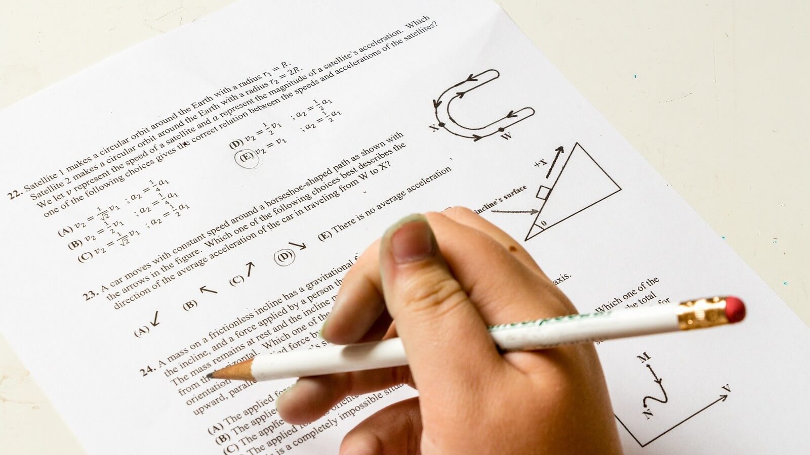 a student taking a hand written test using a pencil and paper. 