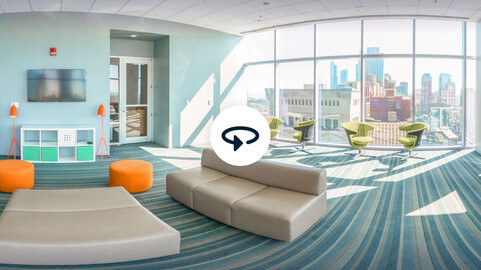 a room with couches and chairs and a large window