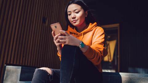 a student calculates her changes of admission on her smart phone