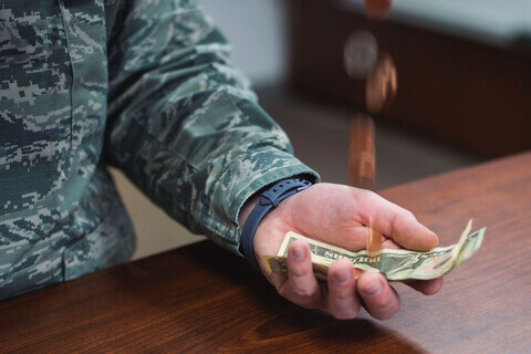 An active duty service member with money in his had