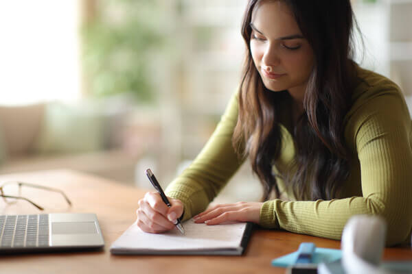 Student writing on notepad