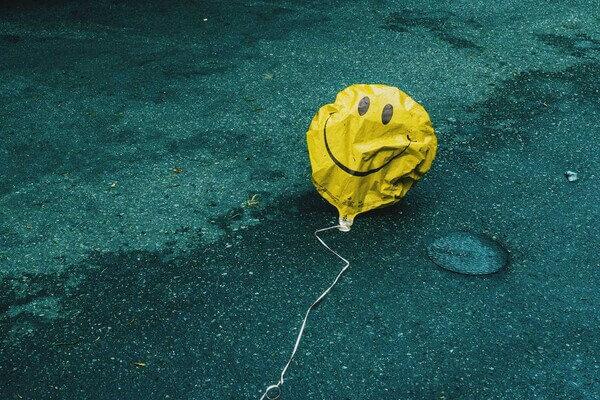 a helium balloon that's lost air sags on the ground