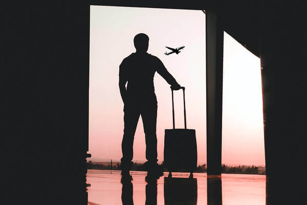 a man stands at the door of an air port looking out