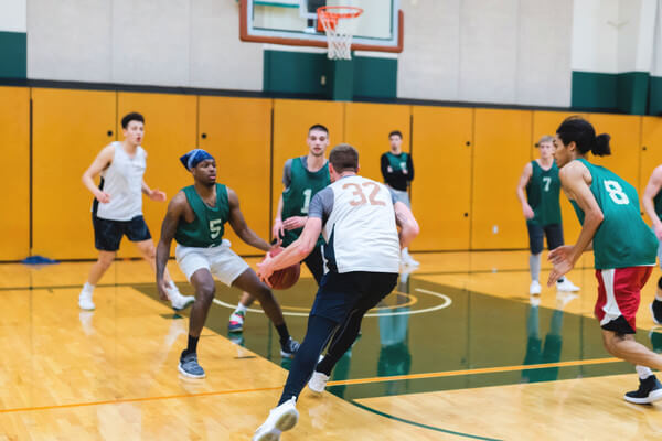 a group of young men playing basketball at an indoor court