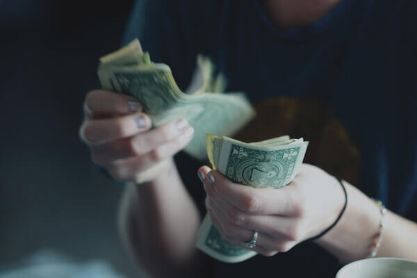 A person counting printed money in their hands.