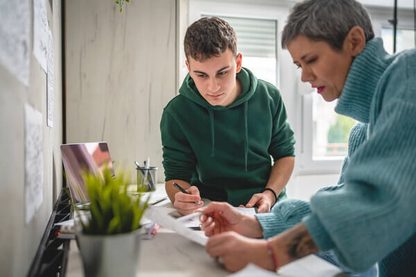 A male student getting information from a female guardian.