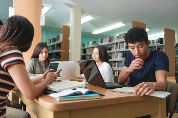 a group of students doing class work in the school library