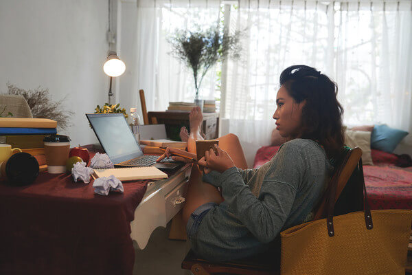 a woman sits at her desk drinking coffee