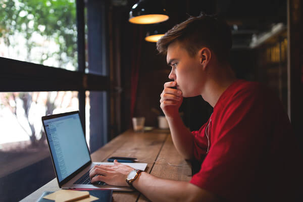 a young man checking admission status on computer