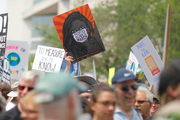 A group of people gathered in the "Peoples Climate March" and holding signs that say, "There Is No Planet B," "Make the E.P.A. Great Again" and "To Measure Is To Know."