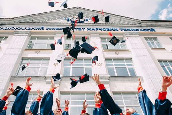 Graduating students throw their caps into the air