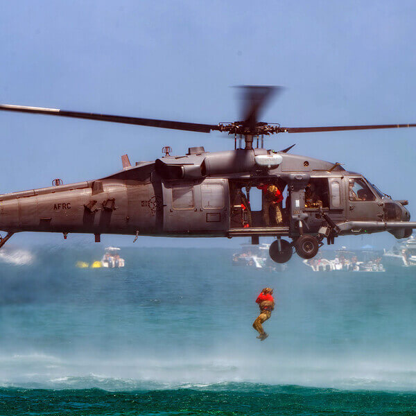 a chopper drops an Air Force swimmer into the ocean