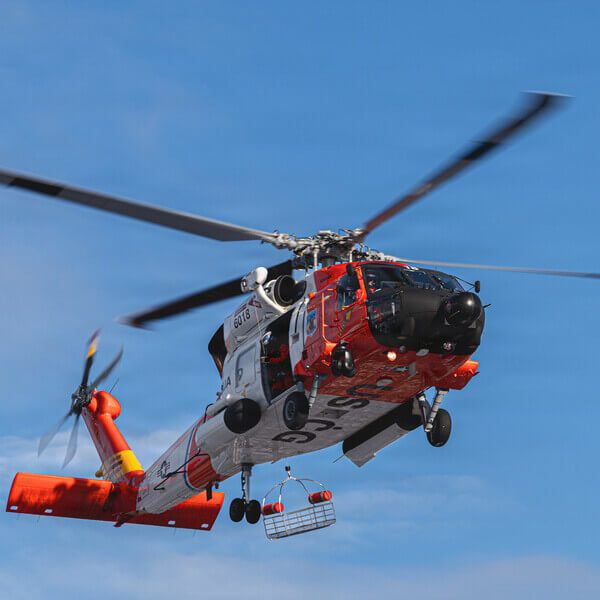 Coast Guard helicopter and rescue swimmer jumping out