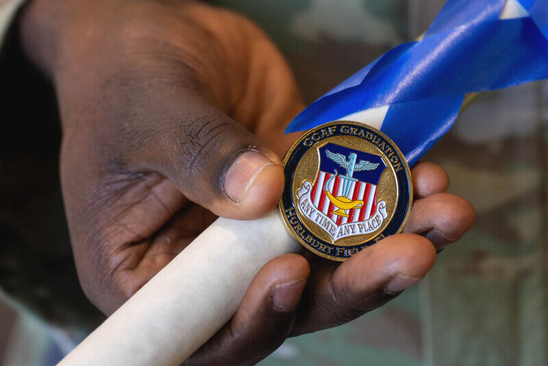 a hand holds a graduation pin