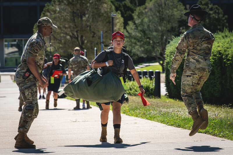 a student and a drill sergeant do PT outside in BDUs 