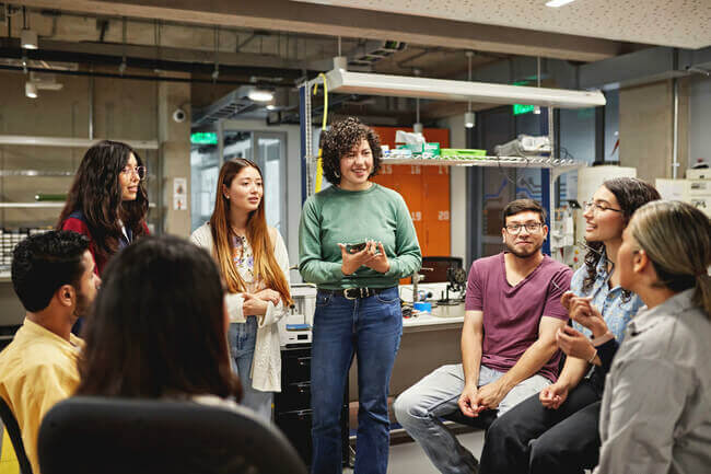 a group of diverse students listening to a speaker during a college tour