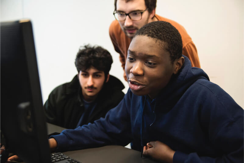 a group of students look at a computer waiting to see their PSAT scores