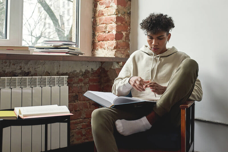 a student plays with a yellow pencil while studying for the SAT