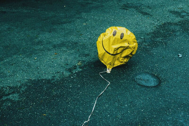 a helium balloon that's lost air sags on the ground