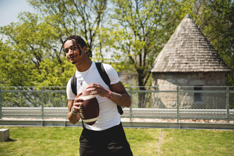 a young man plays football in a field