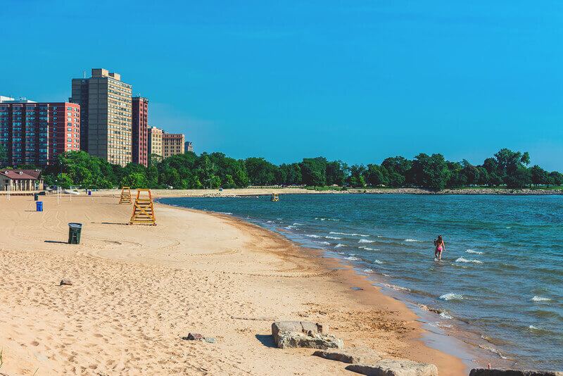 a beach with golden sand an a high rise in the distance
