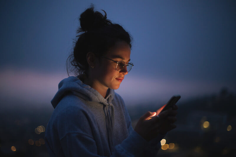 a young lady looks at her phone as she dreams about her future career