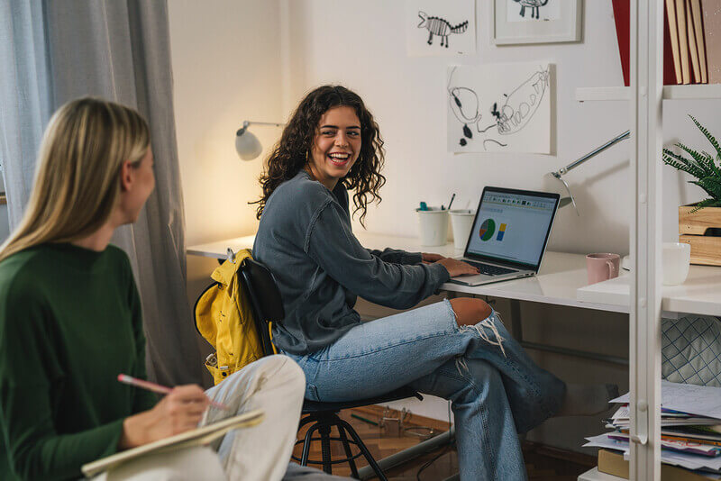 two roommates study in their dorm and talk about classes