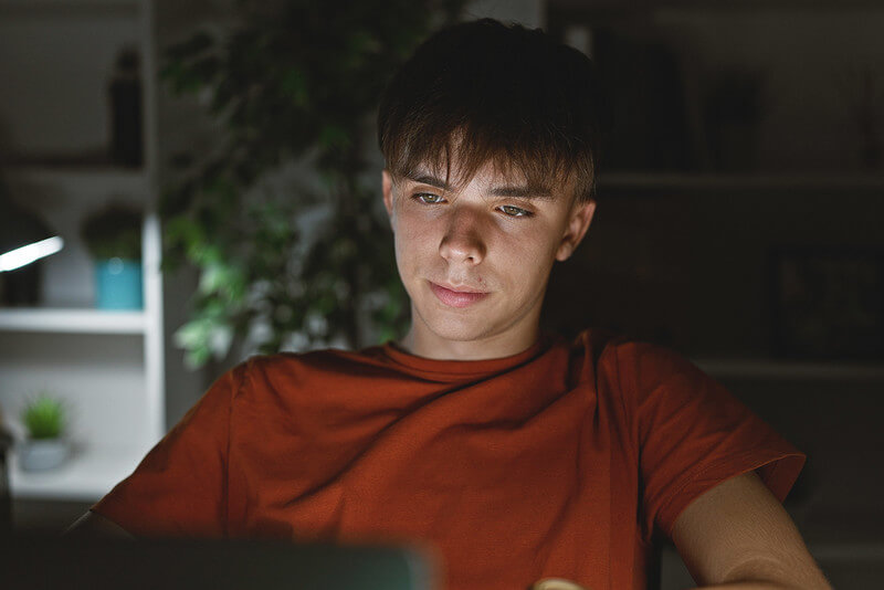a student looks at a computer screen in a dark room