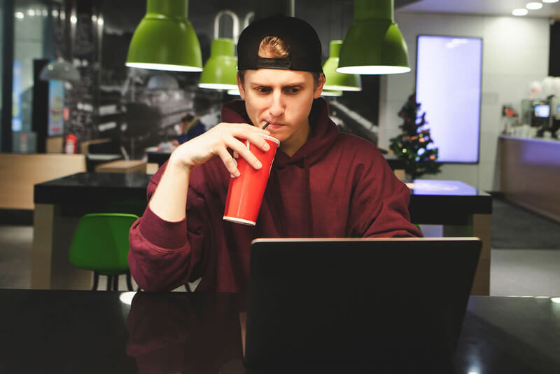 a male student looks at college admission data on his laptop