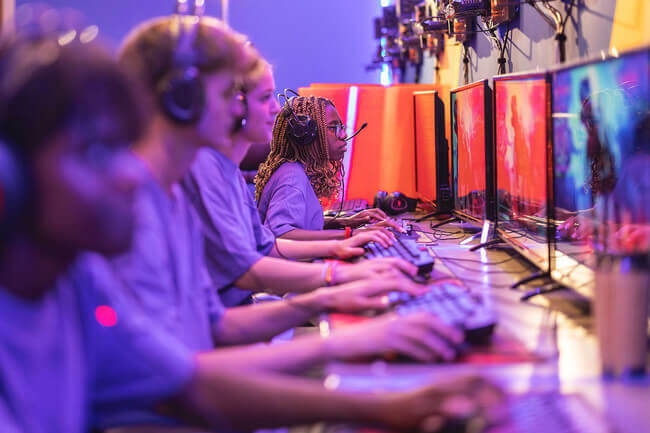 students sit in a row playing esport games on computers