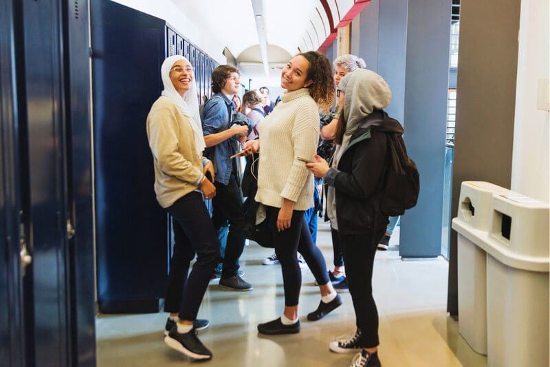 a diverse group of students standing in a school hallway
