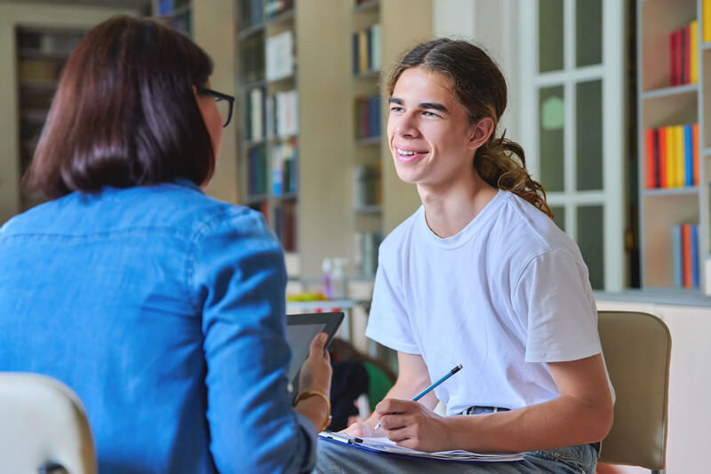 a male student talking to female teacher