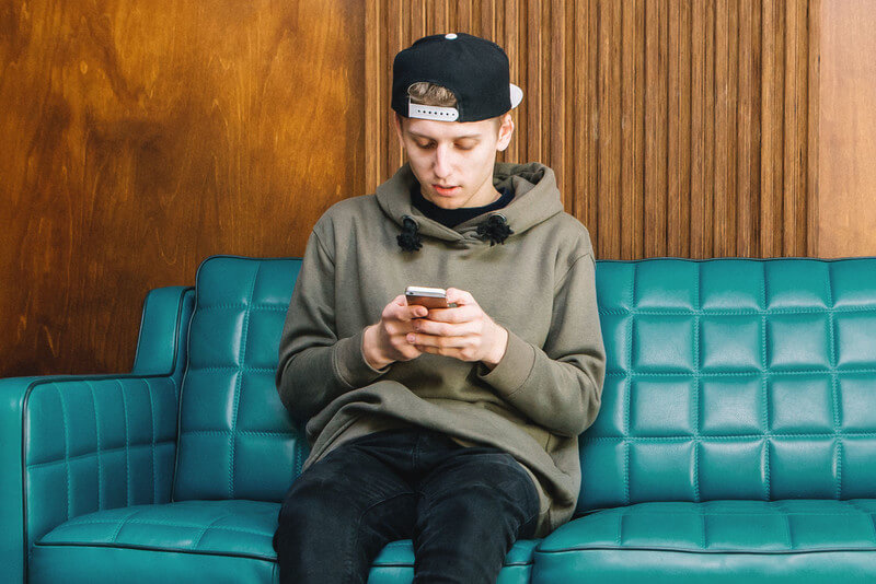 male student looking at test scores on his phone