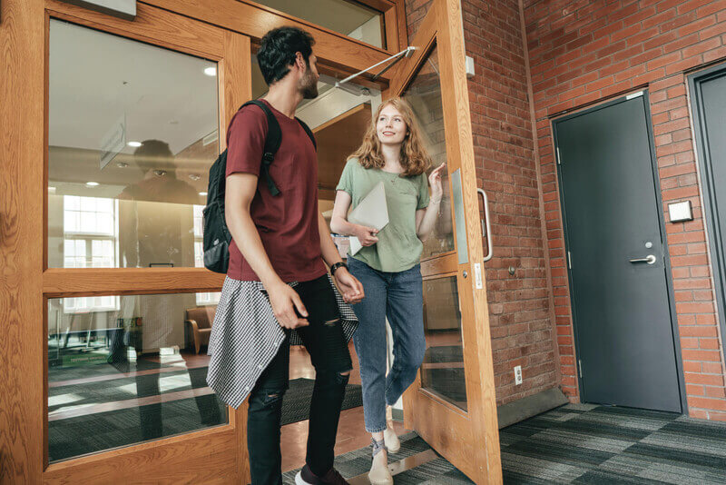 two students walk out of a lecture hall talking