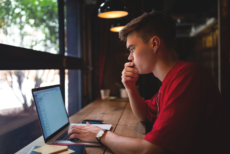 a young man checking admission status on computer