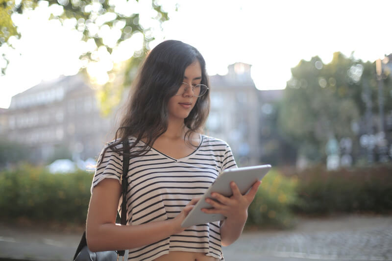 a female student works on an ipad to complete her common app