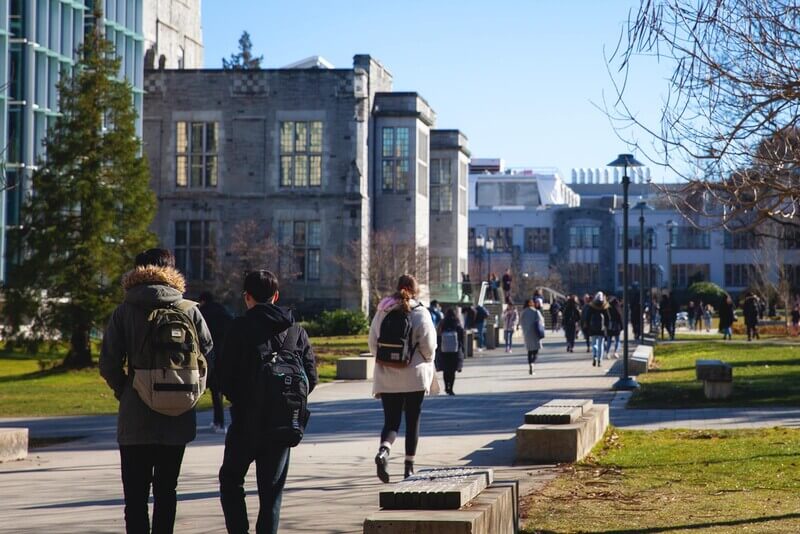 a group of students walks on a college campus