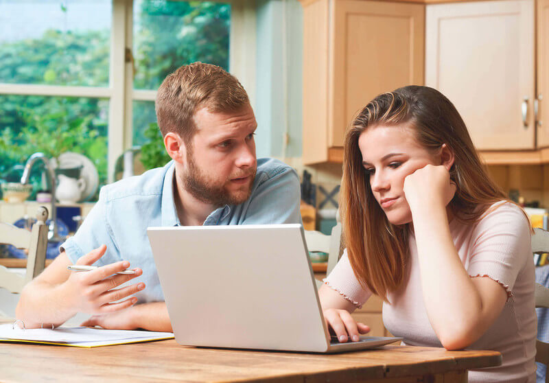 a dad explains to his daughter what being deferred means while she reads the letter from the college on her laptop. 