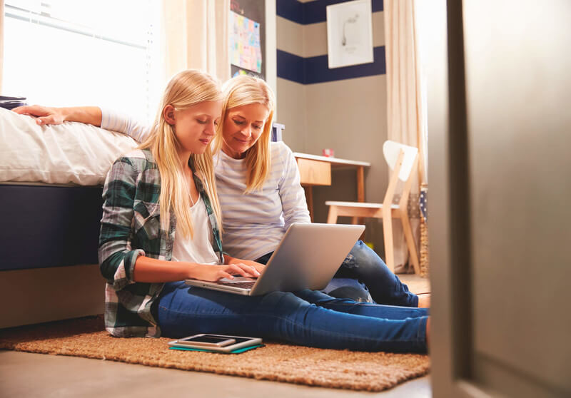 A girl and her mom complete the FAFSA together on a laptop