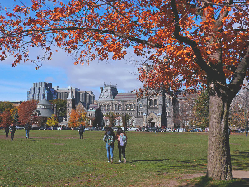students walk across a college campus