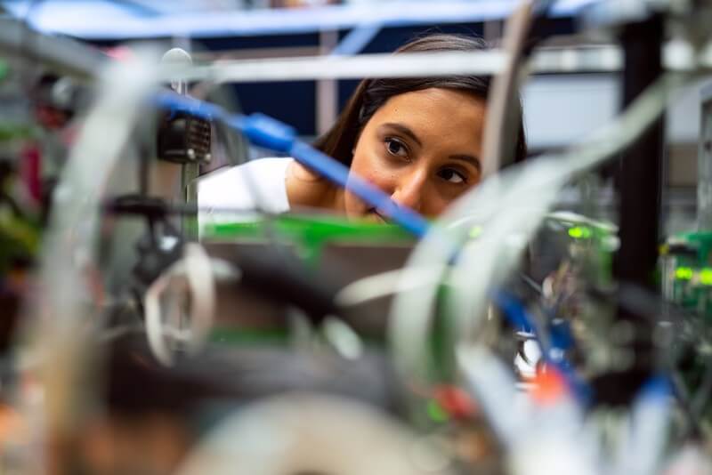 a female student works on an engineering project in a trade school