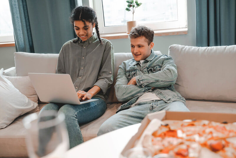 a girl student creates an resume using her laptop and ChatGPT while a boy looks on